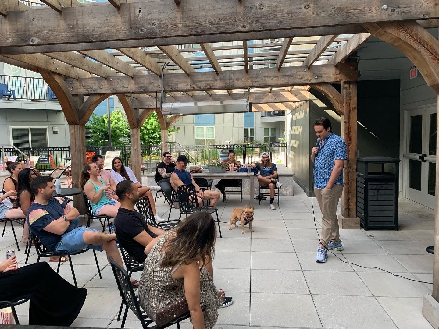 A host mid-punchline at a poolside resident event